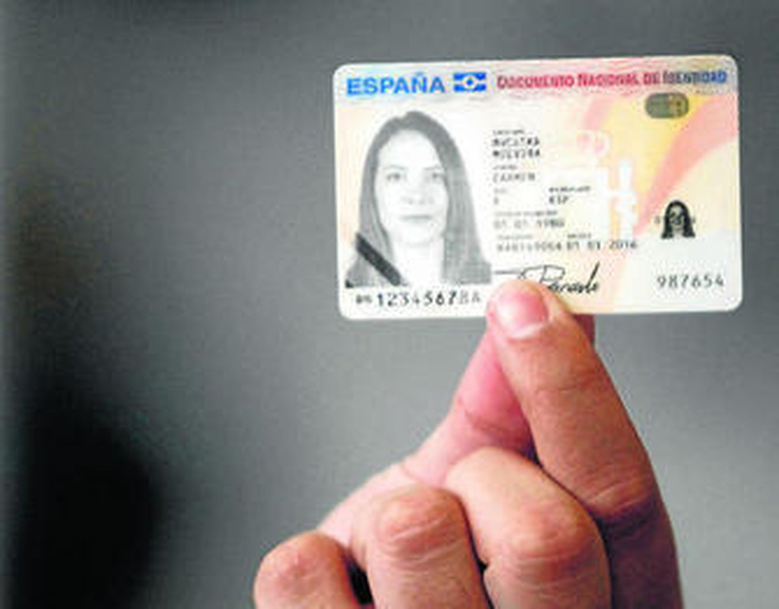 Una persona enseña un modelo de muestra del DNI 3.0.