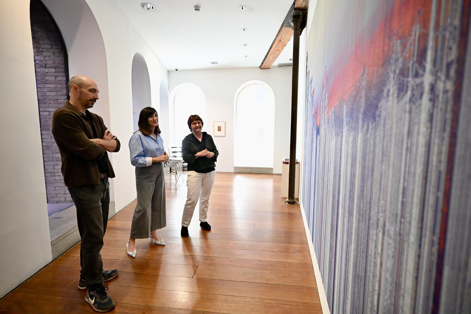El autor junto a la diputada y la comisaria de la muestra.