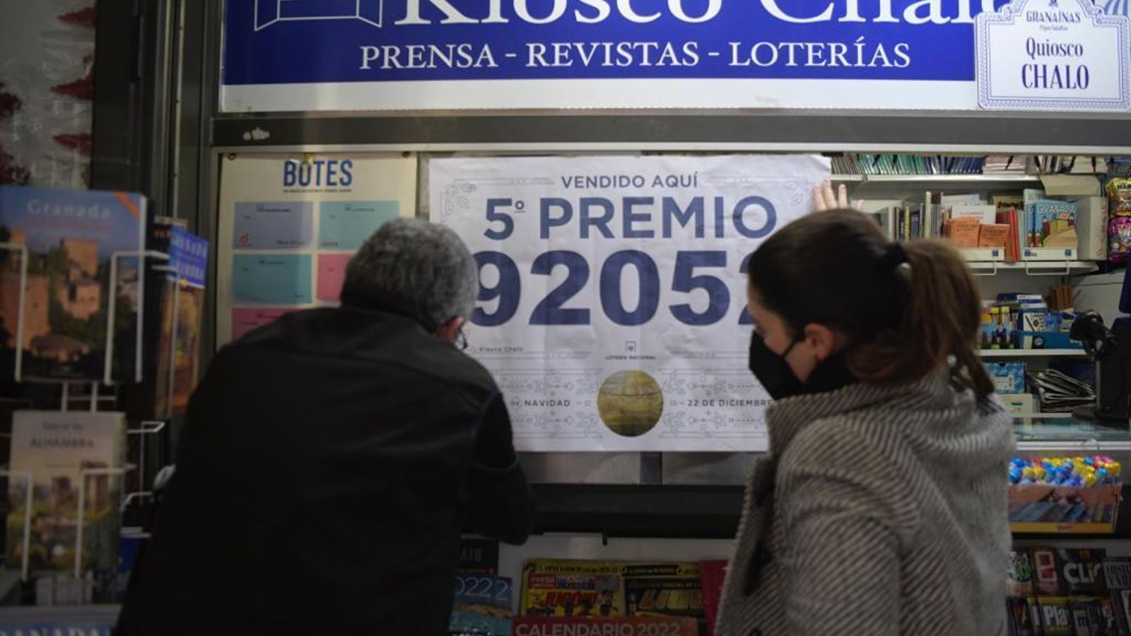 El lotero del Kiosko Chalo de Plaza Nueva cuelga el cartel de haber vendido el quinto premio de la Lotería de Navidad 2021