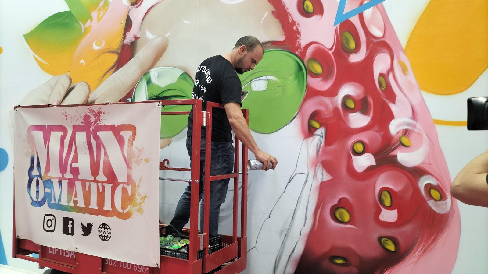 Manomatic pinta el mural en el stand.