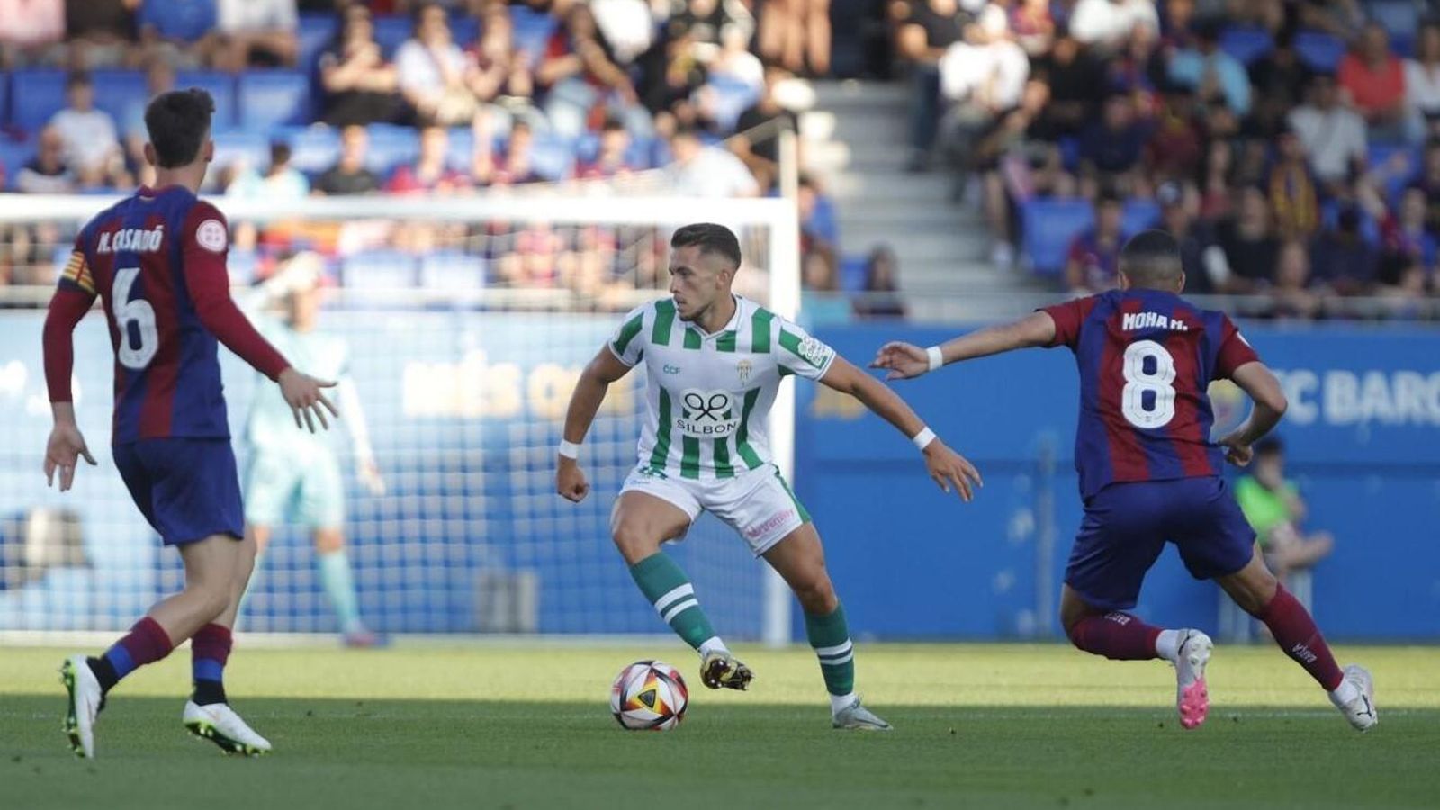 Isma Ruiz conduce el balón entre dos jugadores del Barcelona Atlètic.