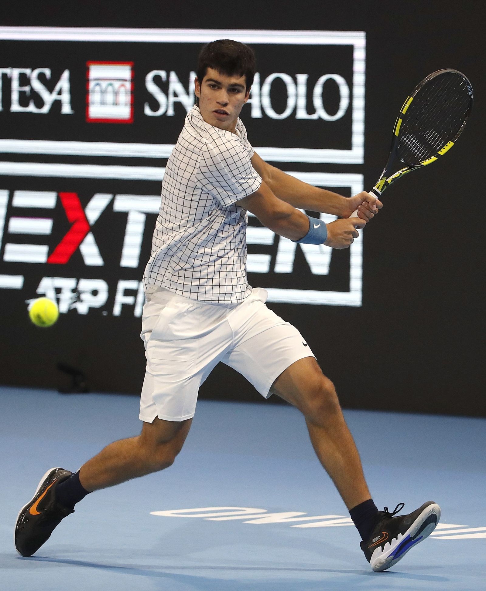 Carlos Alcaraz devuelve con el revés la pelota durante el torneo Next Generation ATP Finals.