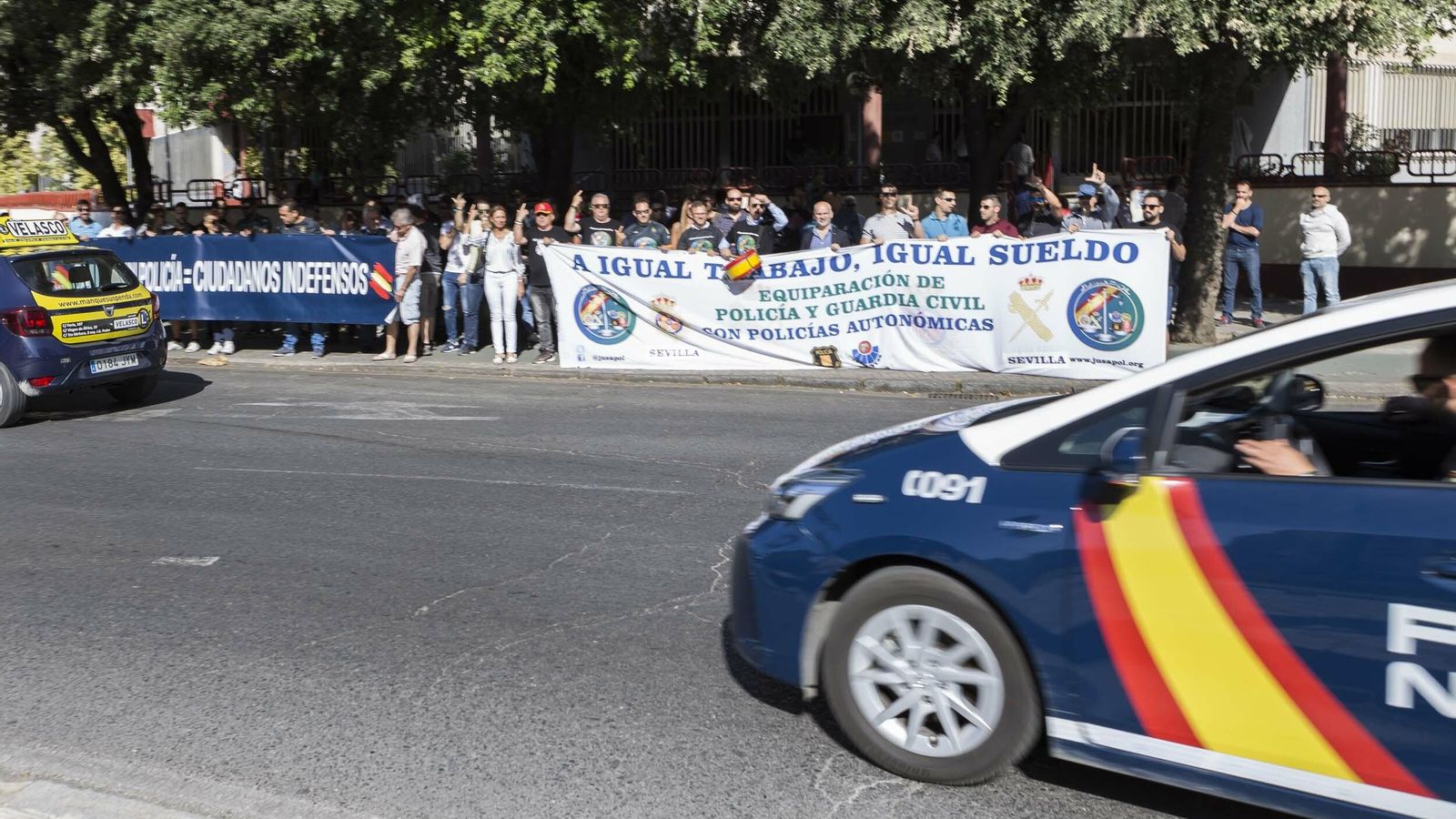 Un patrullero de la Policía pasa ante sus compañeros durante la concentración.