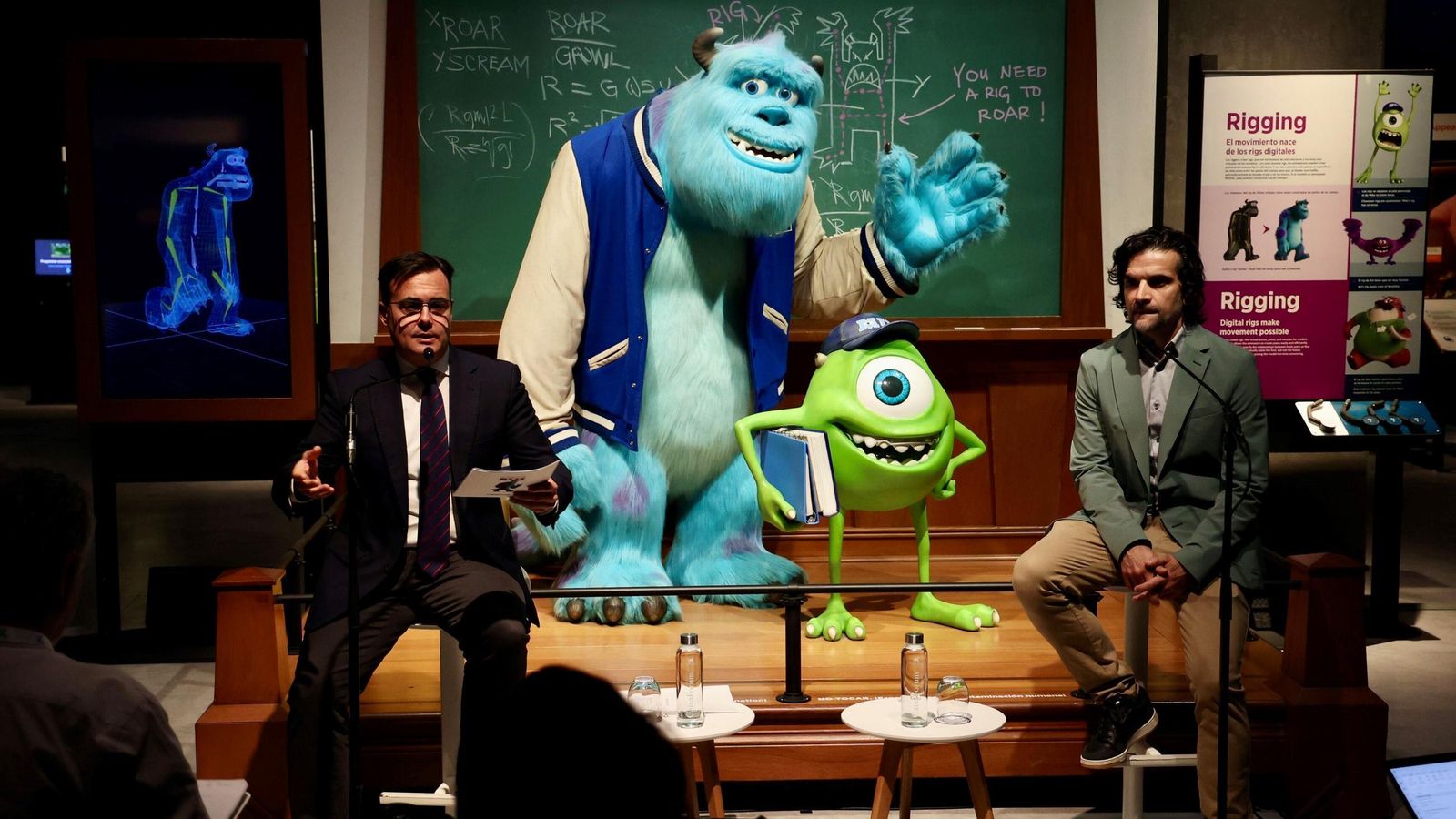 Moises Roiz, director de CaixaForum Sevilla y el director de Exposiciones y Actividades de Ciencia de Fundación La Caixa, Javier Hidalgo, con una reproducción de Sullye y Mike Wasowski, de Mosntruos S. A.