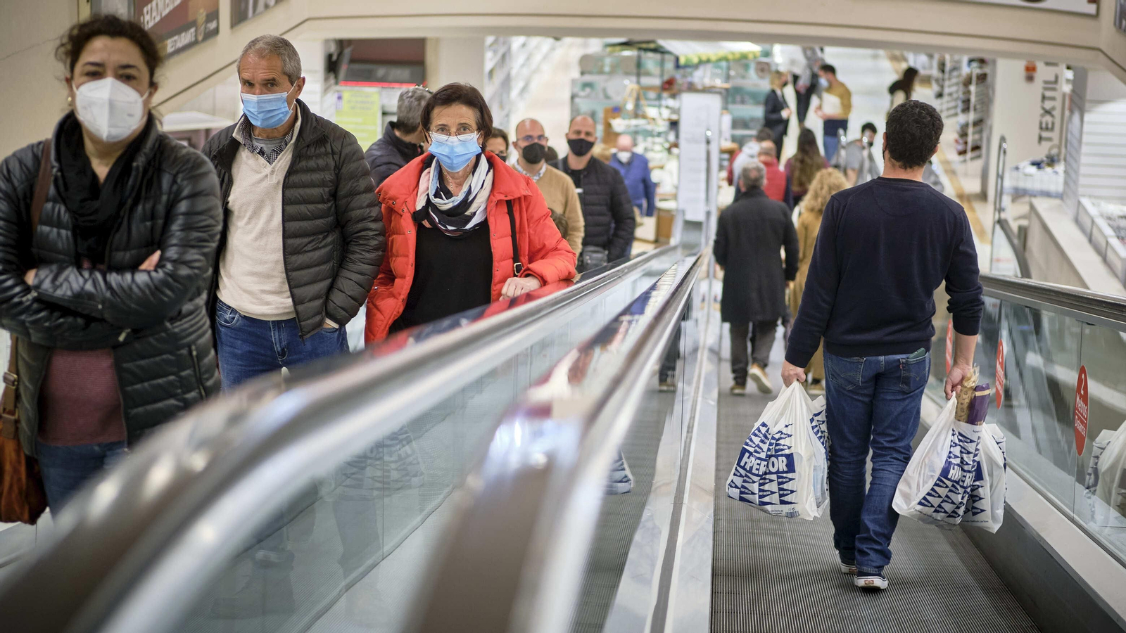 Gente en las escaleras mecánicas de un centro comercial