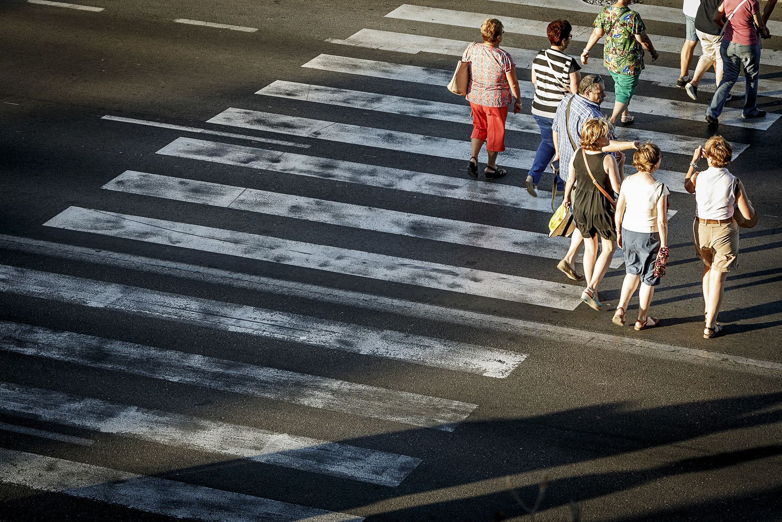 Un grupo de personas cruzando por un paso de peatones.