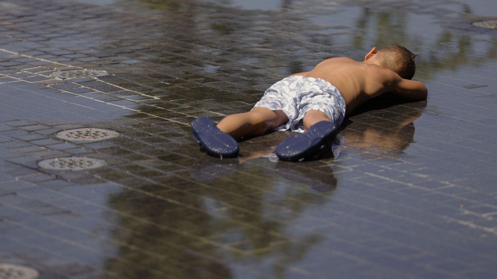 Un niño se refrescan en una zona de agua | Imagen de archivo