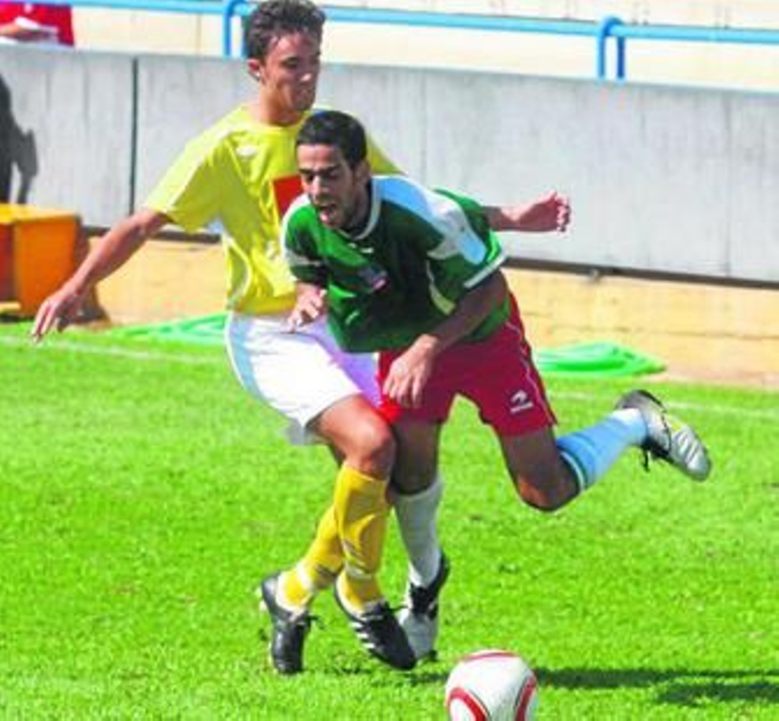 El jugador del Coria Quintero derriba al delantero marinaleño Cisco.