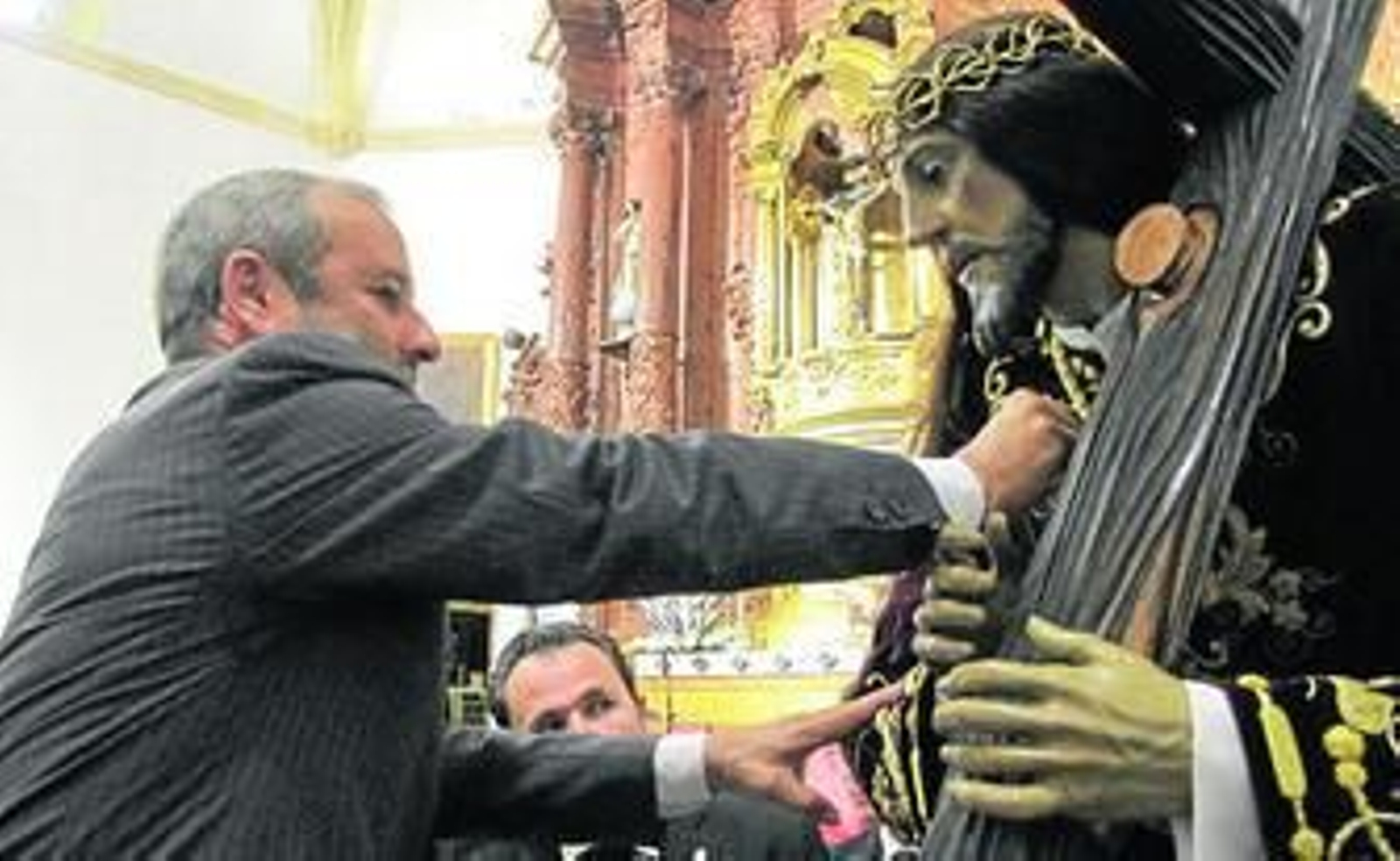 El alcalde coloca la medalla a Nuestro Padre Jesús Nazareno.