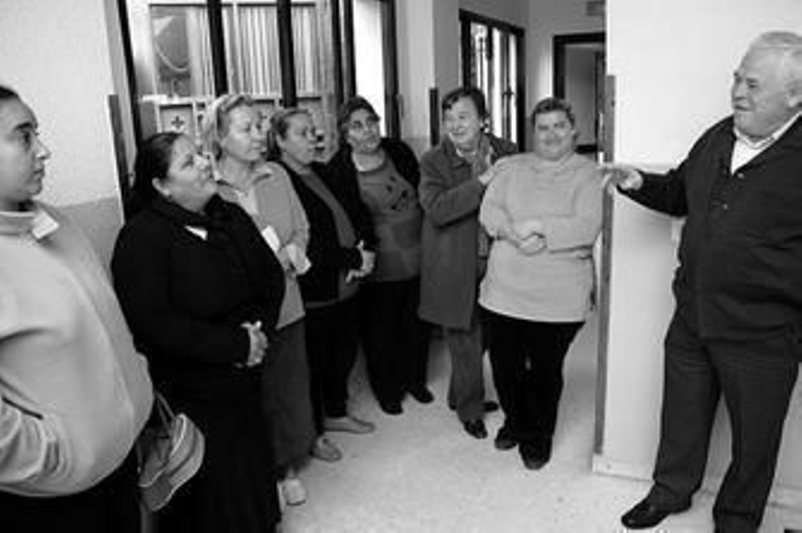 Hipólito Gómez y María Paz Siboni (tercera por la izquierda) charlan con seis mujeres en Cáritas.