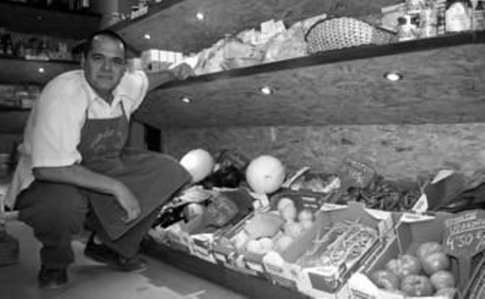 Rafael Román posa en su tienda 'Mundo verde' rodeado de frutas y verduras ecológicas.