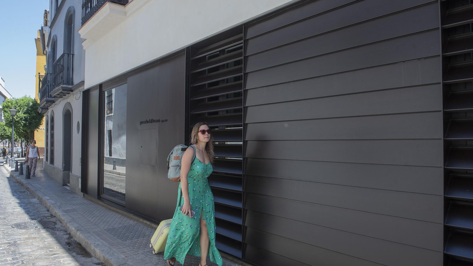 Una mujer pasa a la altura de la entrada al establecimiento hotelero.
