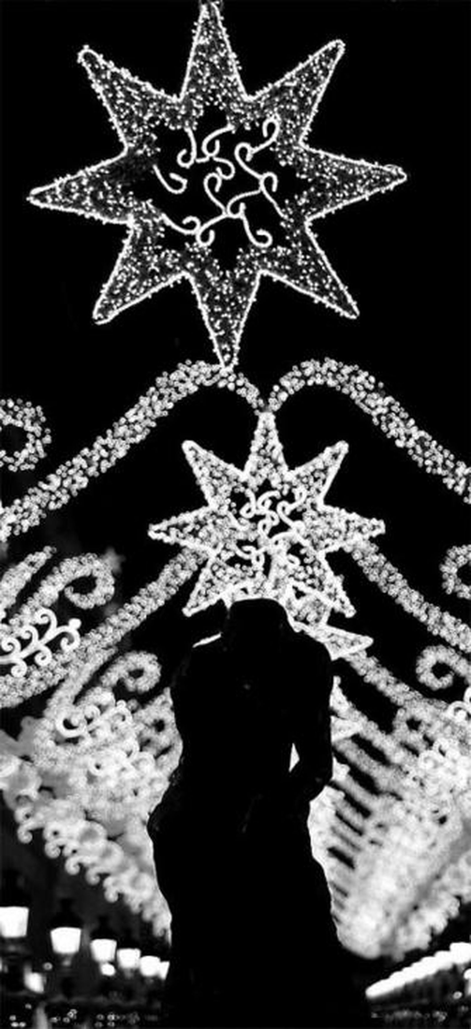 Bajo el alumbrado navideño, la silueta de 'El pensador'.