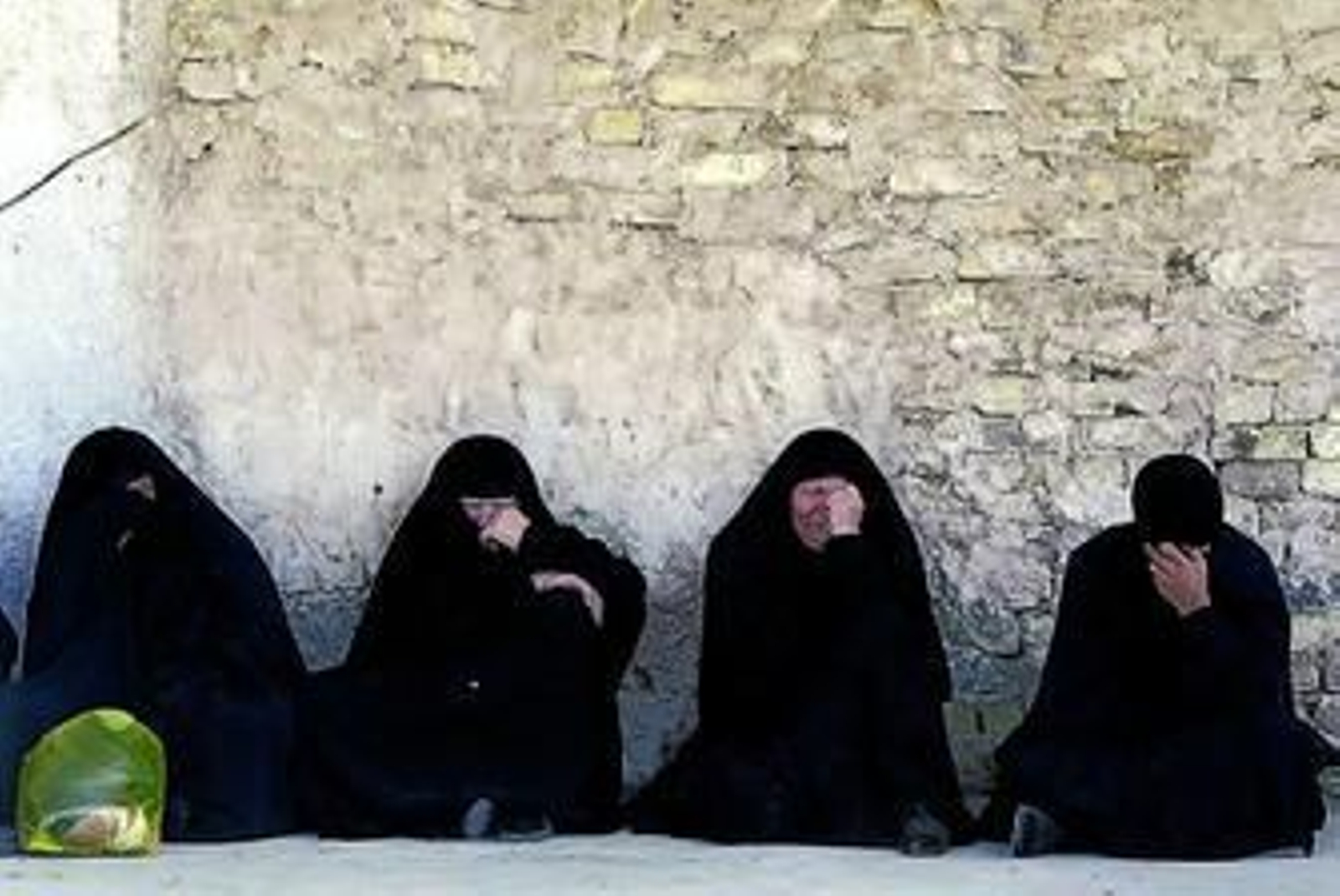 Cuatro mujeres iraquíes lloran sentadas la muerte de varios familiares.