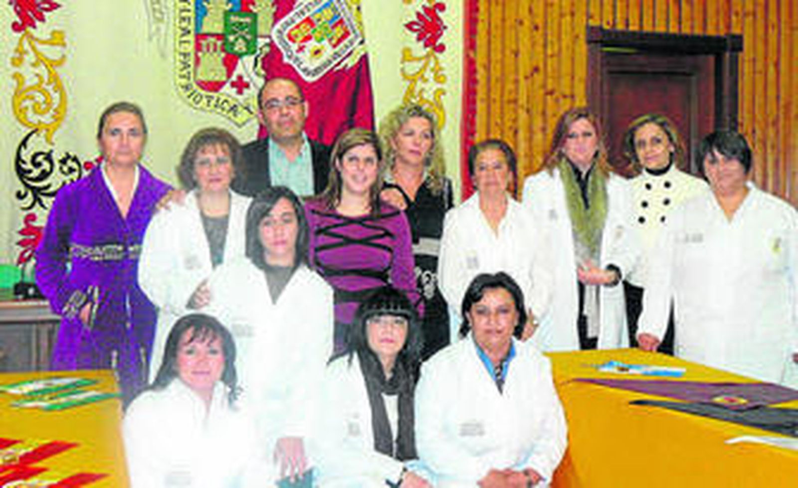 Alumnas y monitora posan ante la bandera.