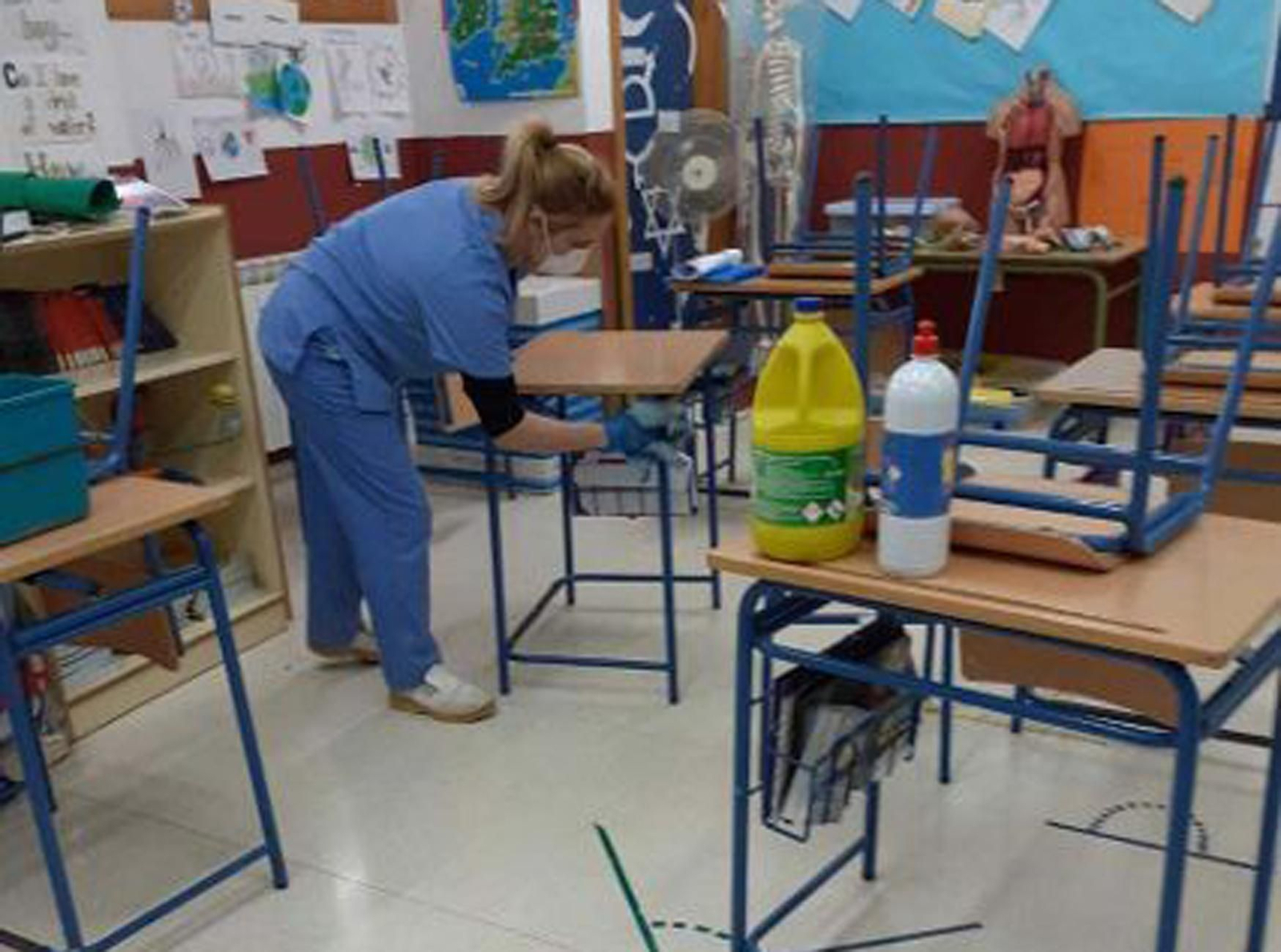 Una empleada limpia un aula de un colegio de Puente Genil.