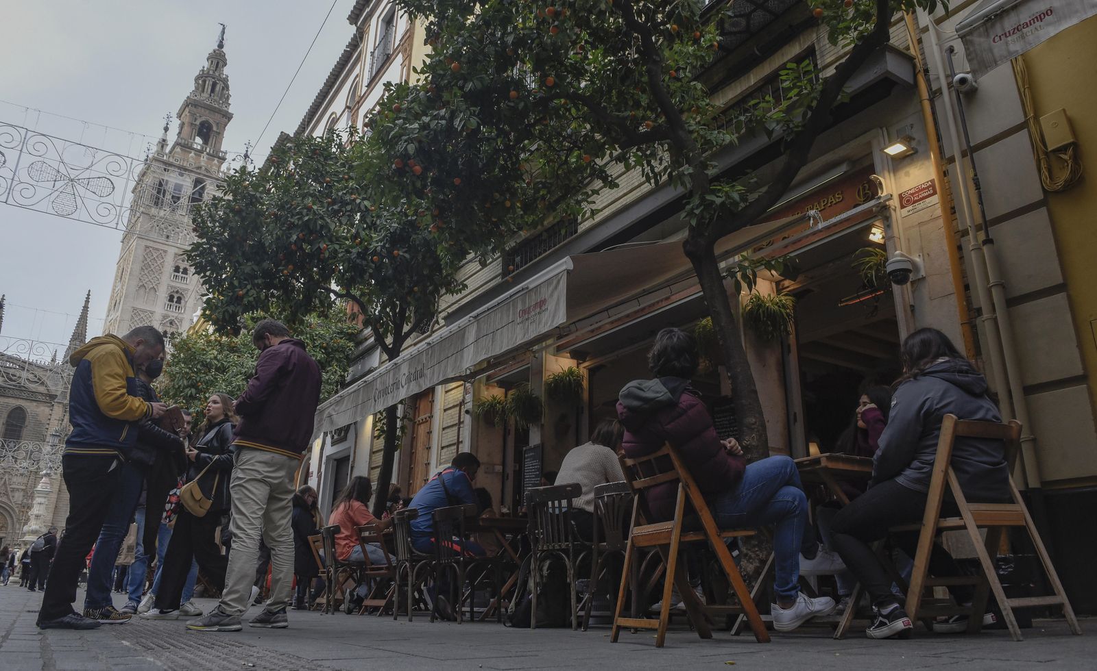 Varias personas coinciden en una céntrica calle de la ciudad de Sevilla.