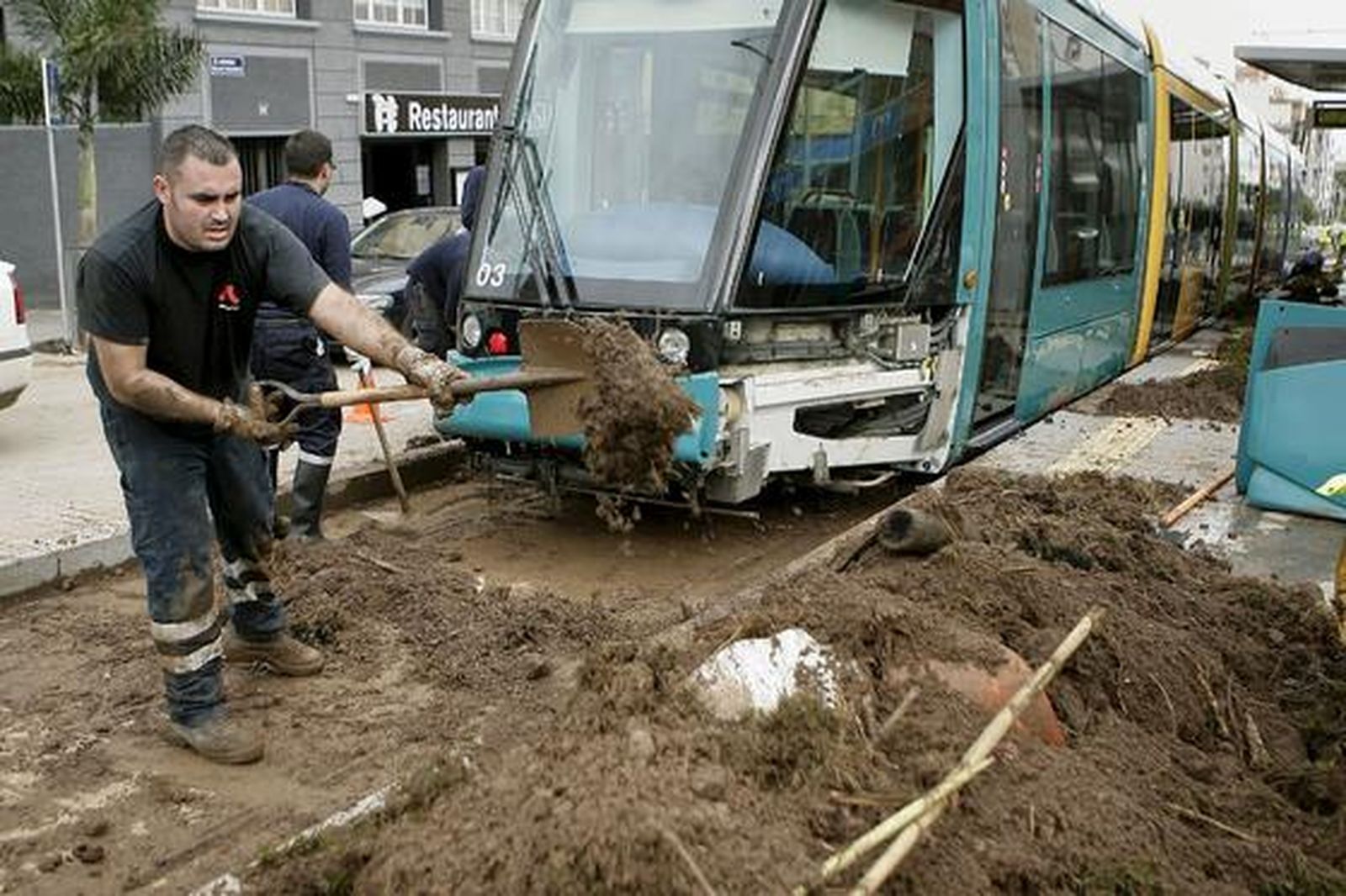 Bomberos retiran el barro acumulado en las vías del tranvía tras las fuertes lluvias caídas en Tenerife. 

Foto: Cristóbal García (Efe)