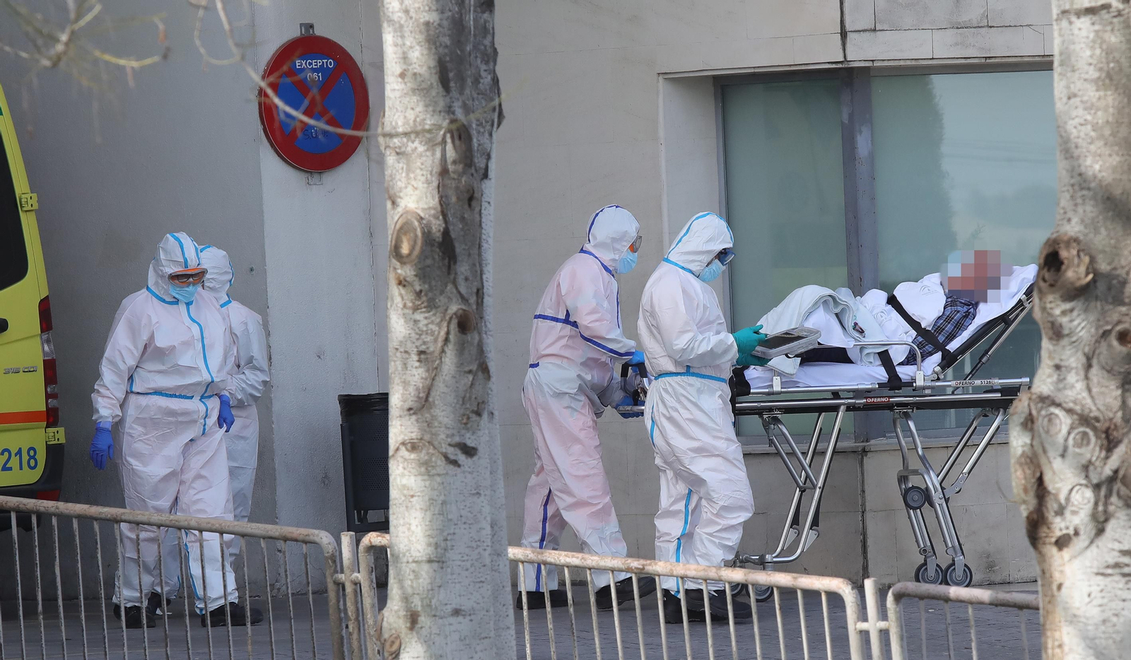 Sanitarios, con los equipos de protección, llevan a un paciente a Urgencias.