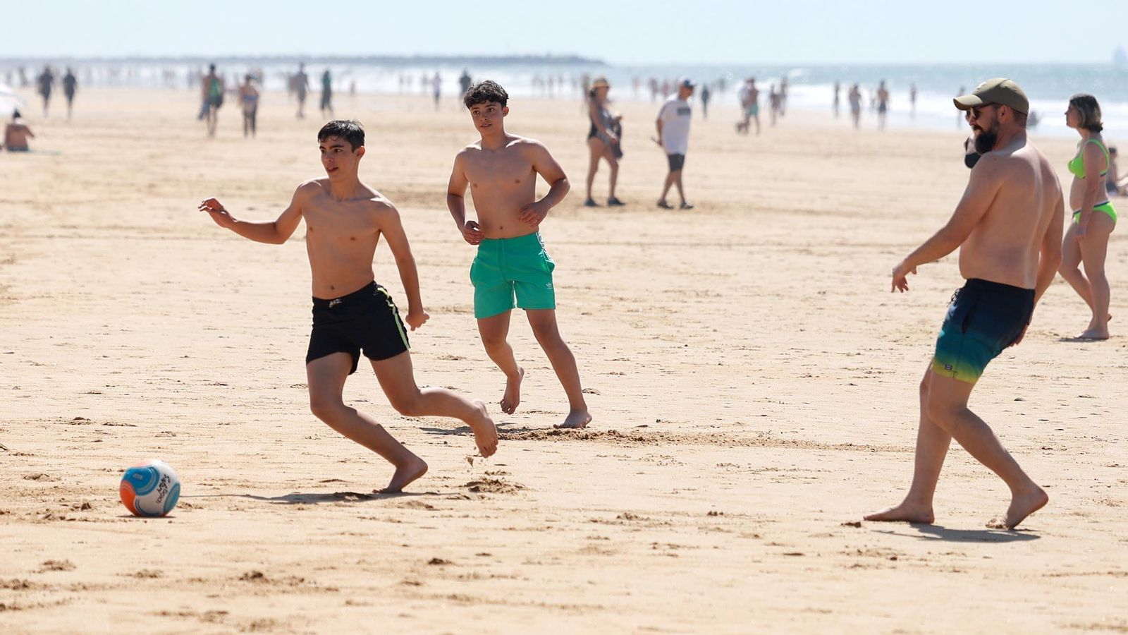 Personas jugando al fútbol en la playa de Punta Umbría. Personas jugando al fútbol en la playa de Punta Umbría.