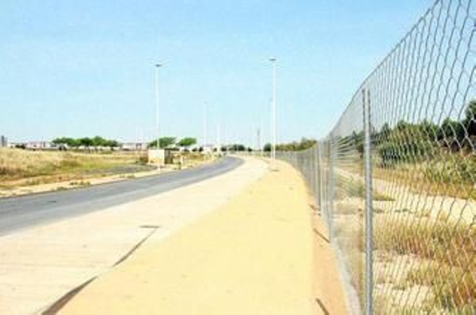 A la derecha, vallas en parcelas municipales en la zona arqueológica del Seminario, con solares enfrente sin cerrar.