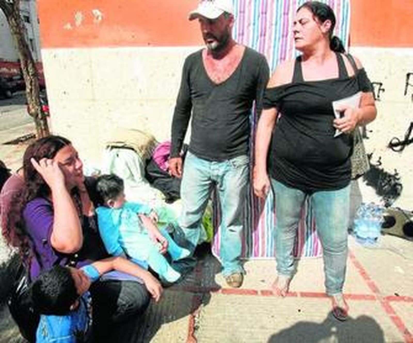 Ana María sostiene ayer al más pequeño de sus hijos, junto a su marido y su hermana.