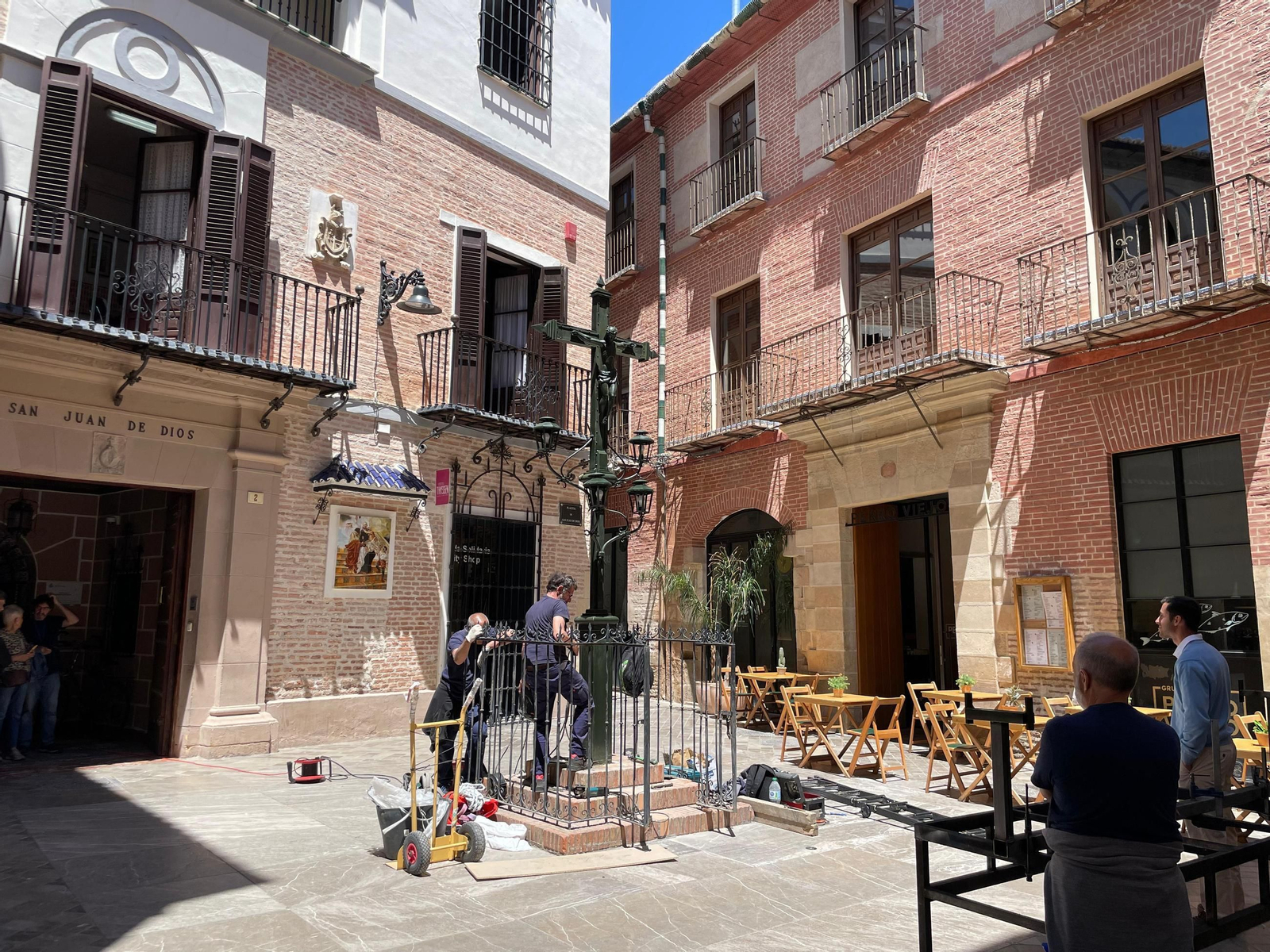 Operearios colocan la Cruz de vuelta en la plaza San Juan de Dios