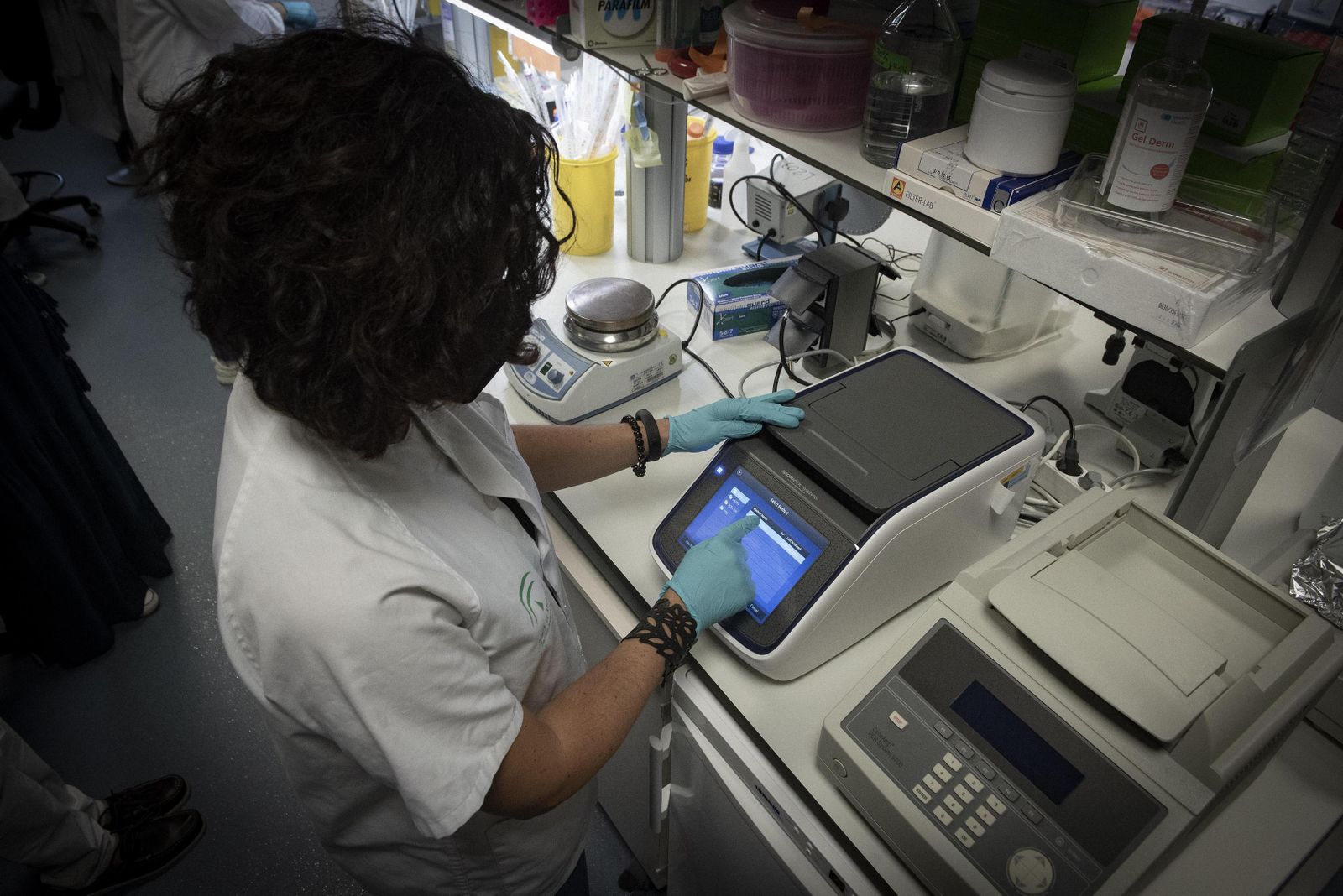 Una investigadora maneja tecnología de laboratorio.