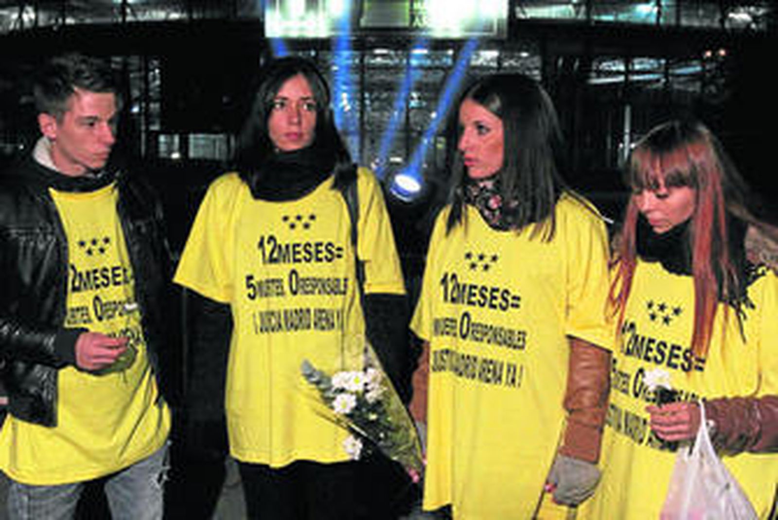 Varios jóvenes durante la vigilia celebrada anoche junto al Madrid Arena en recuerdo de las cinco víctimas de la tragedia.