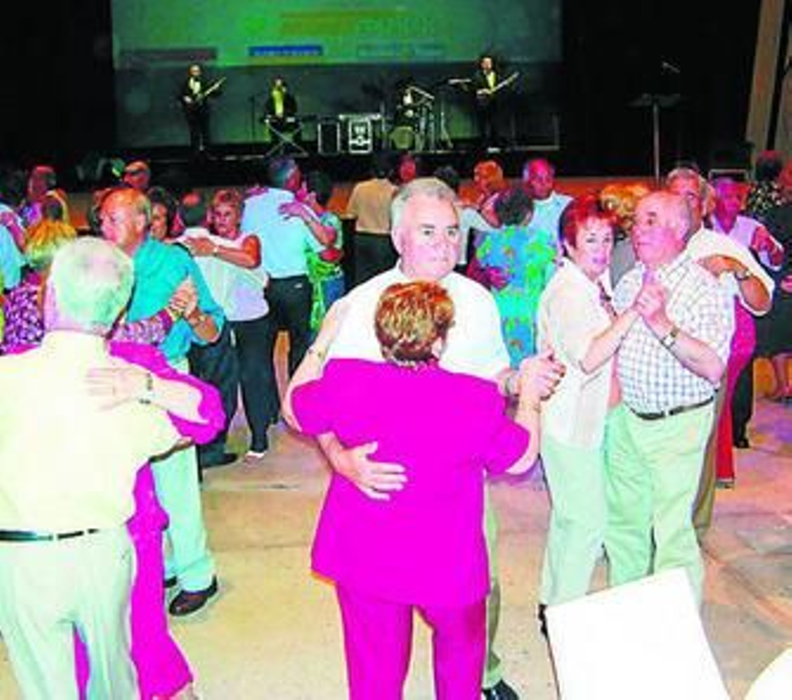 Varias personas bailan en un hotel en una estancia de vacaciones por el Imserso.