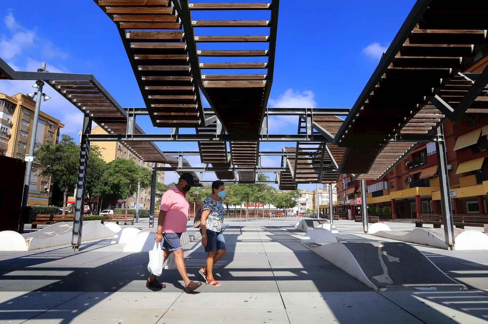 Dos personas pasean por un parque de la capital onubense.
