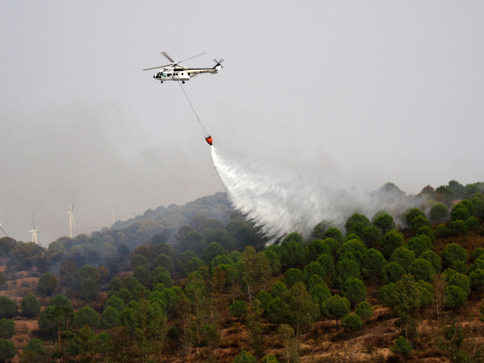 Uno de los helicópteros desplazados a El Granado, en plena descarga.
