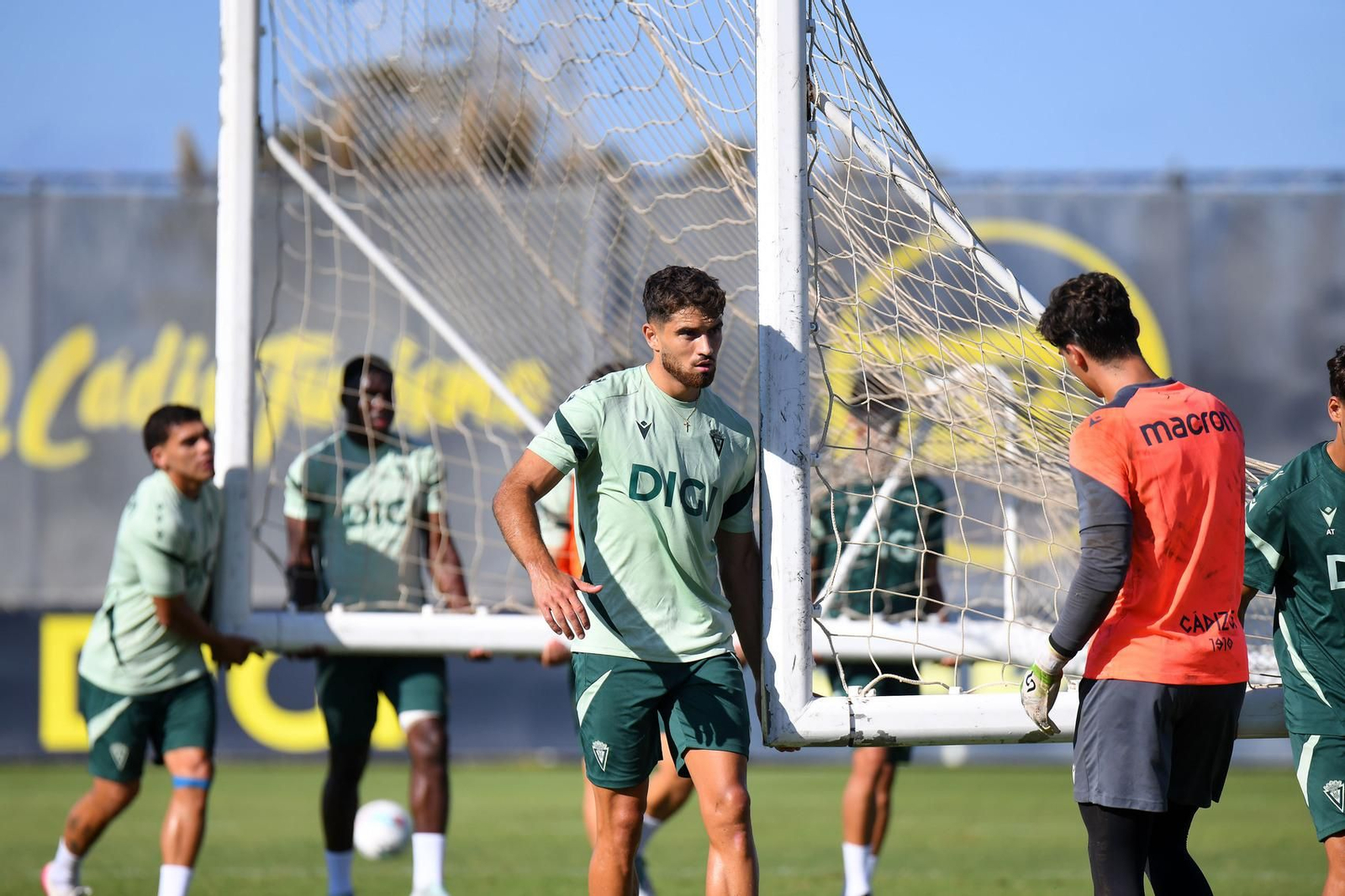 Jugadores del Cádiz trasladan una portería en un entrenamiento.