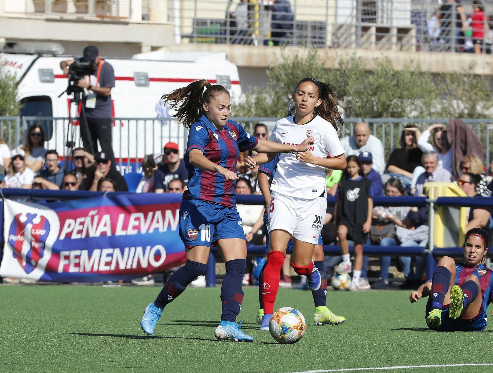 La levantinista Banini busca apoyos ante la presión de la sevillista Isabella.