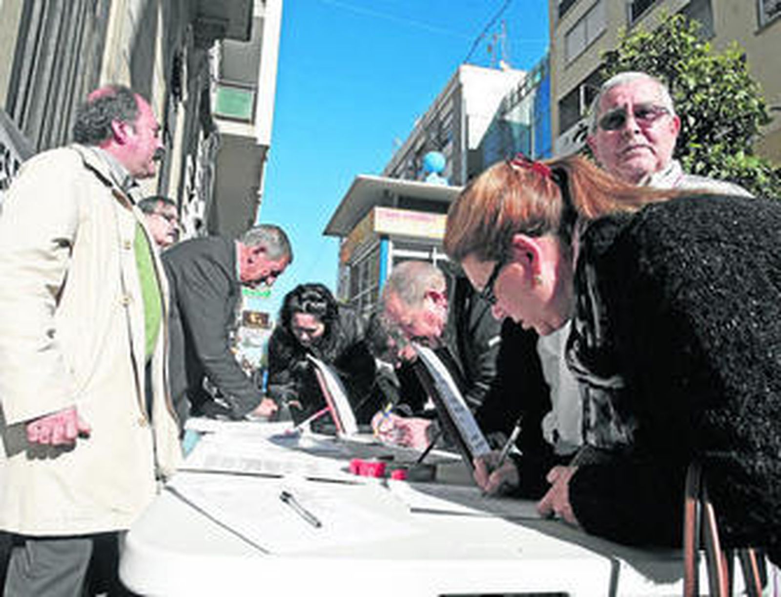 Ciudadanos firman en la mesa de la plataforma instalada en la calle Ancha, ayer.