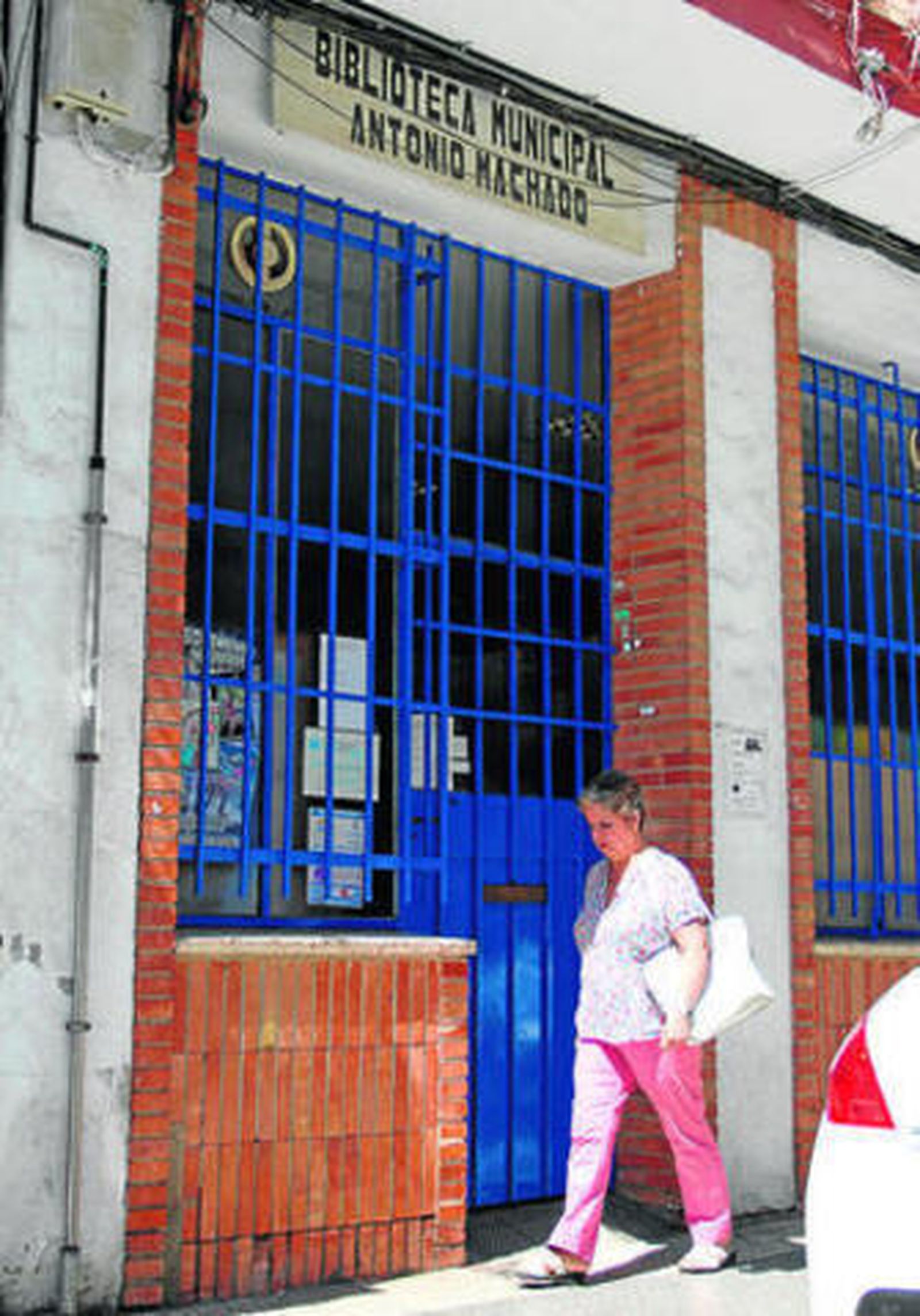 Una mujer pasa por la puerta de la biblioteca municipal Antonio Machado.