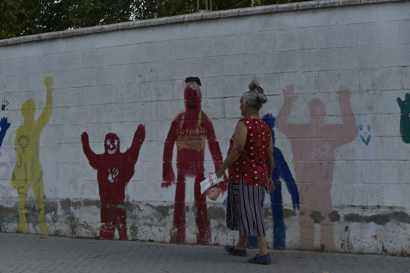 Una señora camina por una calle del Polígono Sur