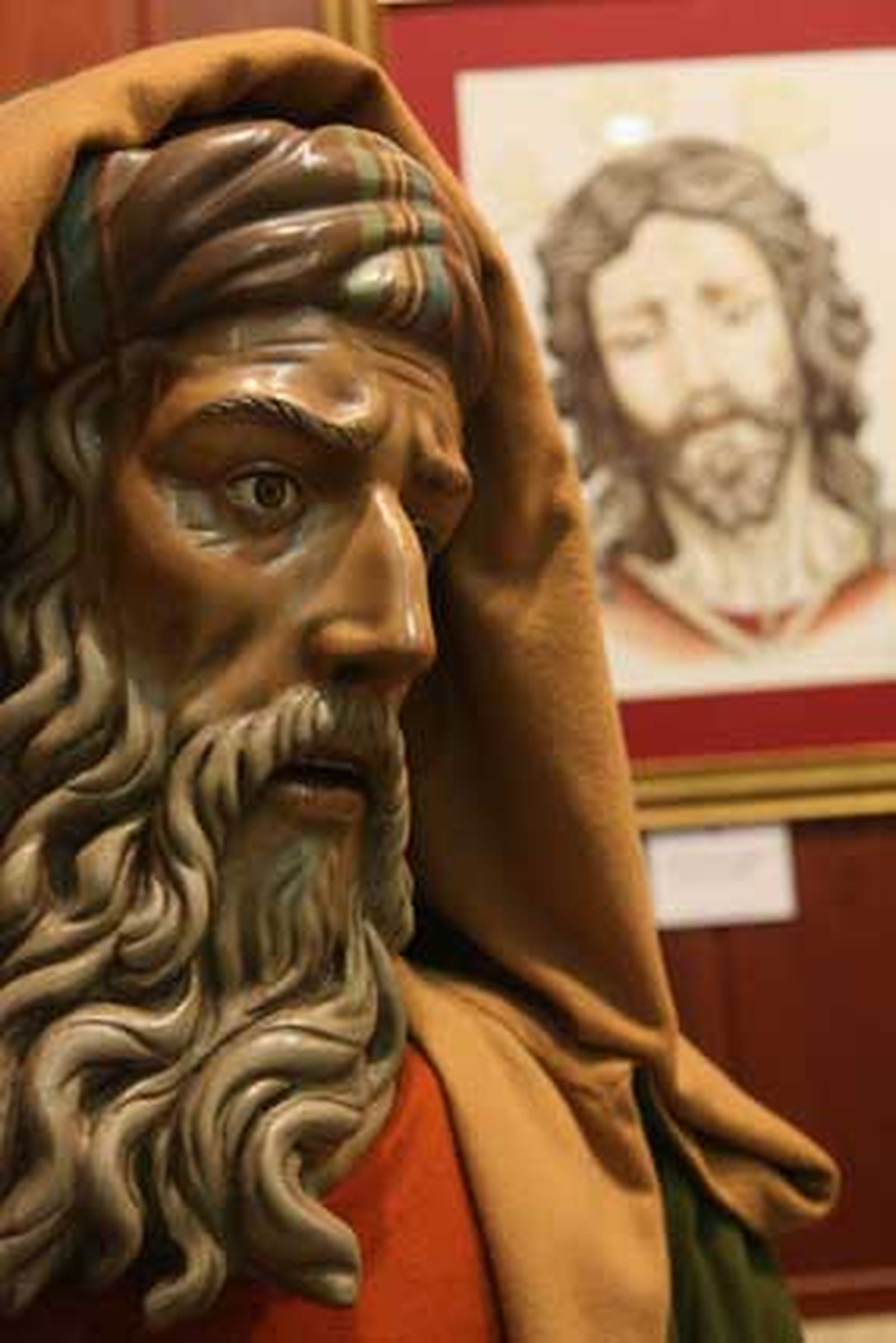 Un sayón del paso de Pino Montano junto a un dibujo del Cristo de dicha hermandad.

Foto: ascarrasco