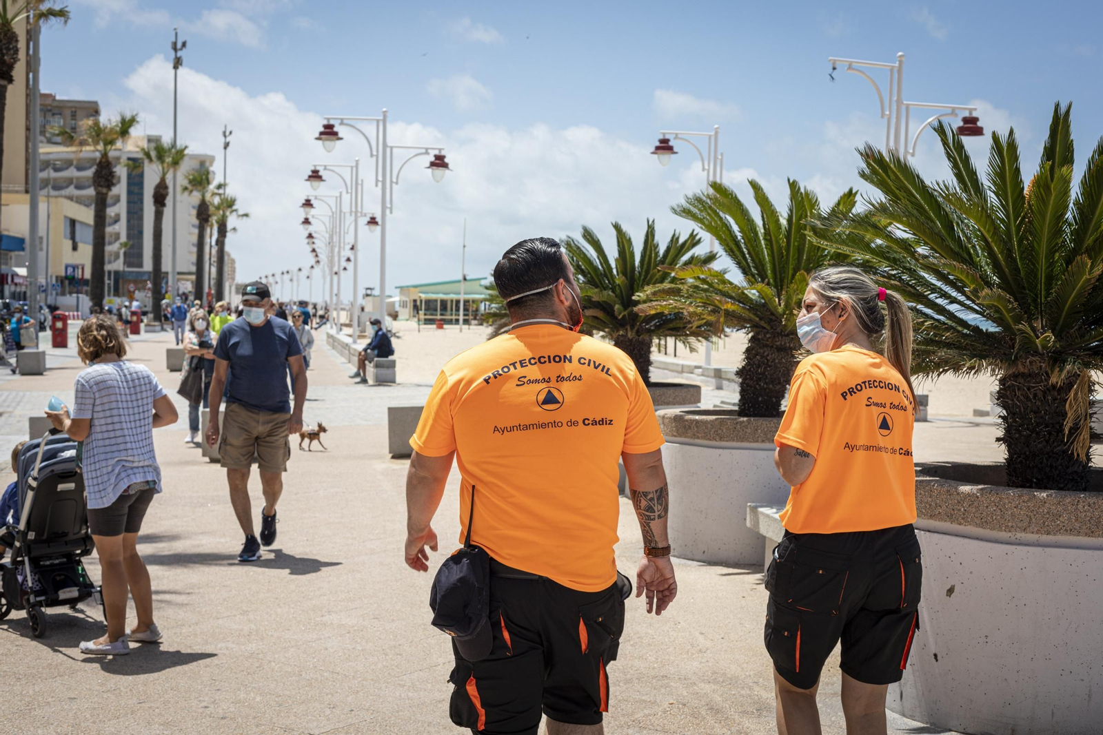 Imagen de ayer de dos miembros de Protección Civil andando por el Paseo Marítimo de Cádiz.