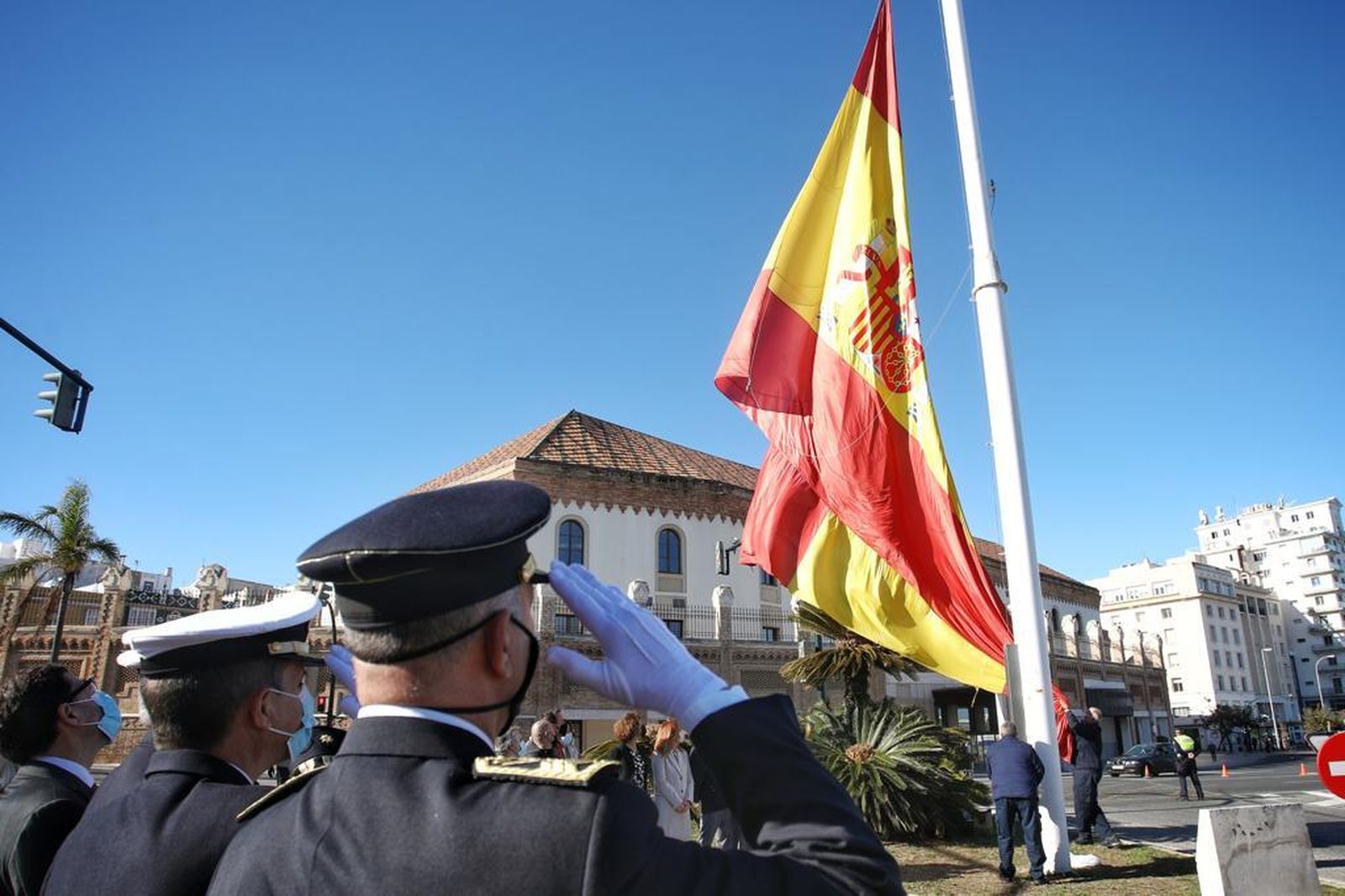 Izado de la bandera española en el mástil de la plaza de Sevilla.