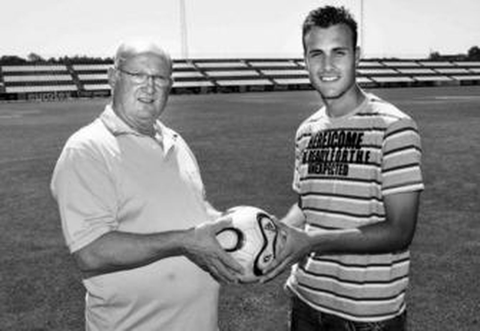 Paco Gallego y Cala, el pasado y el futuro en el Sevilla, sostienen un balón en la ciudad deportiva.