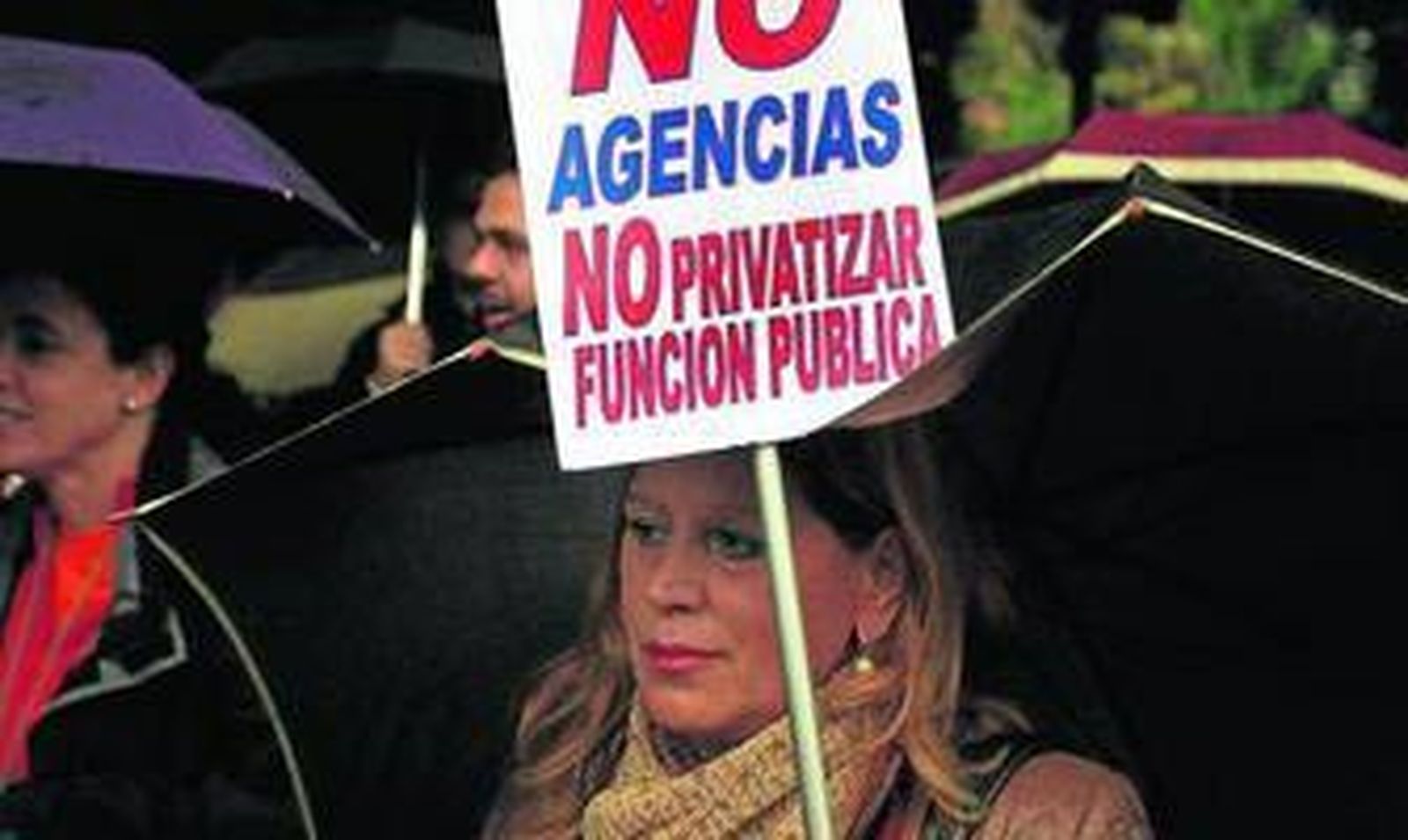 Una funcionaria porta un cartel contrario a la privatización de la función pública.