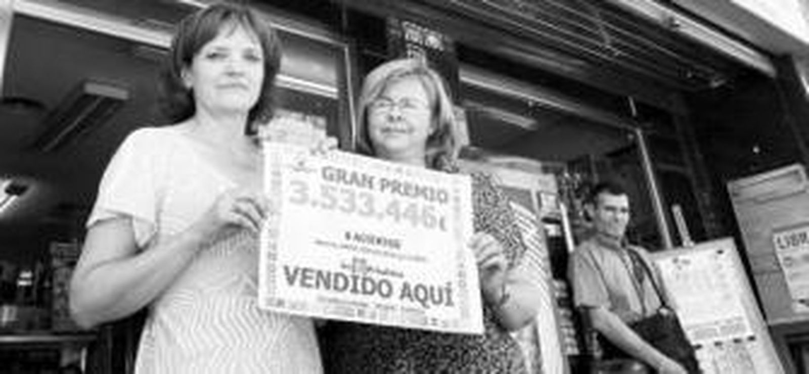 La titular del estanco muestra el premio de la Lotería Primitiva.