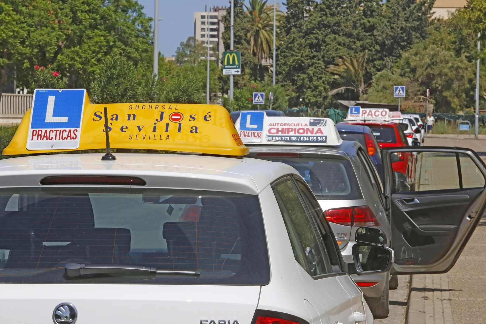 Retrospectiva de unos coches esperando para que sus alumnos hagan el examen práctico en Jerez.