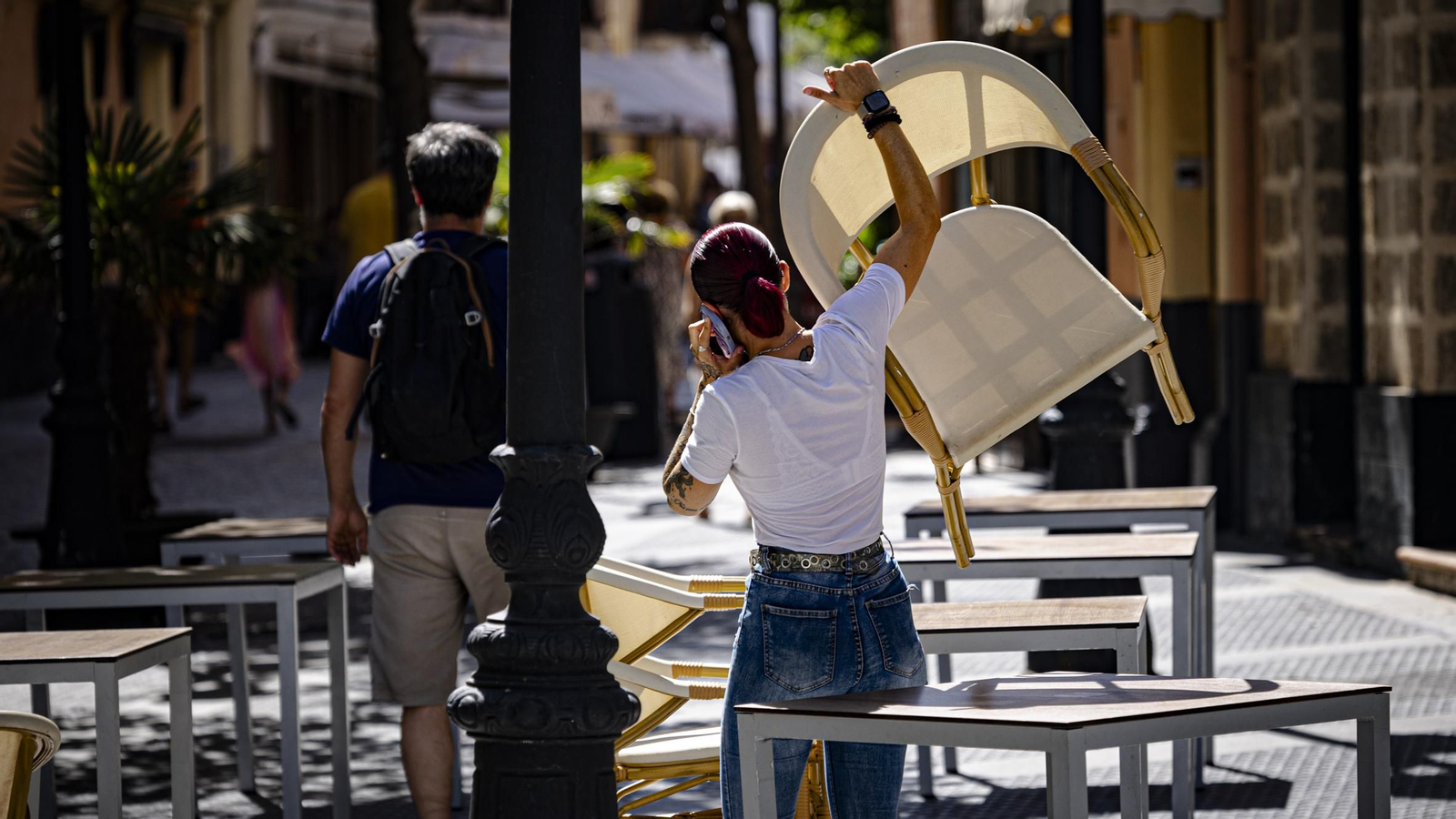 Una trabajadora montando una terraza de un bar