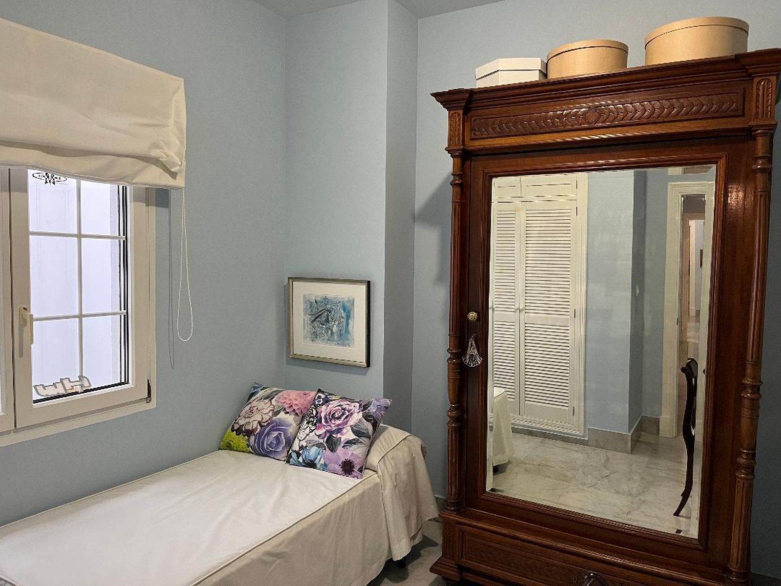 Dormitorio de invitados. Armario alfonsino de nogal con una puerta de espejo, que aumenta la visión de la habitación.