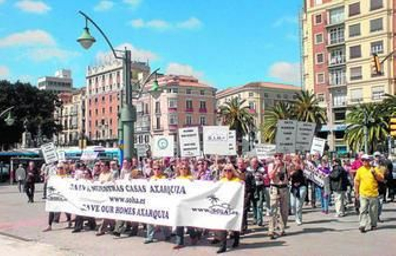 Cientos de personas, ayer, cruzan por el semáforo de la Plaza de la Marina con pancartas y bocinas.