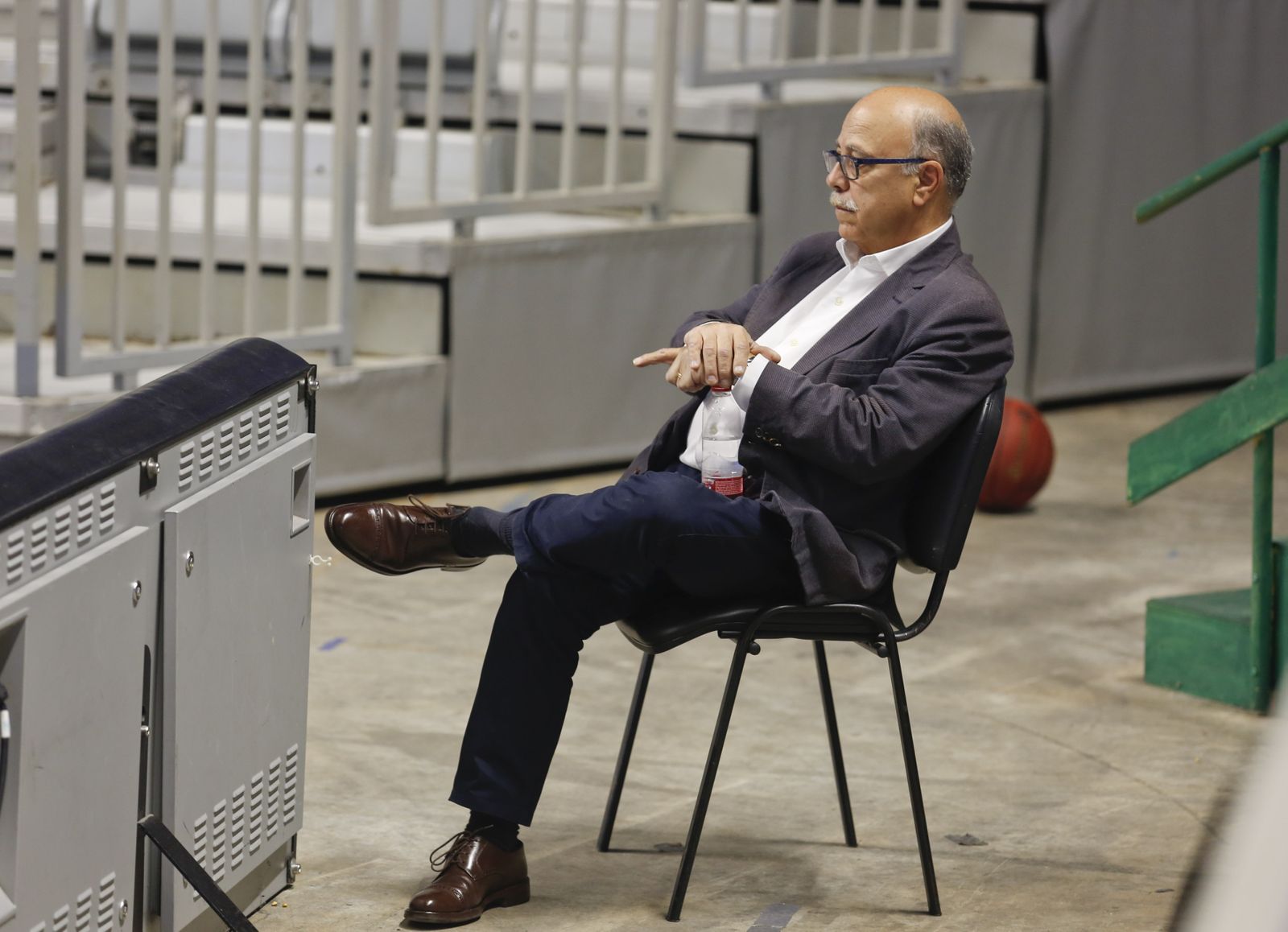 Eduardo García sentado en una silla en el Martín Carpena mientras contempla un entrenamiento del Unicaja la campaña anterior.