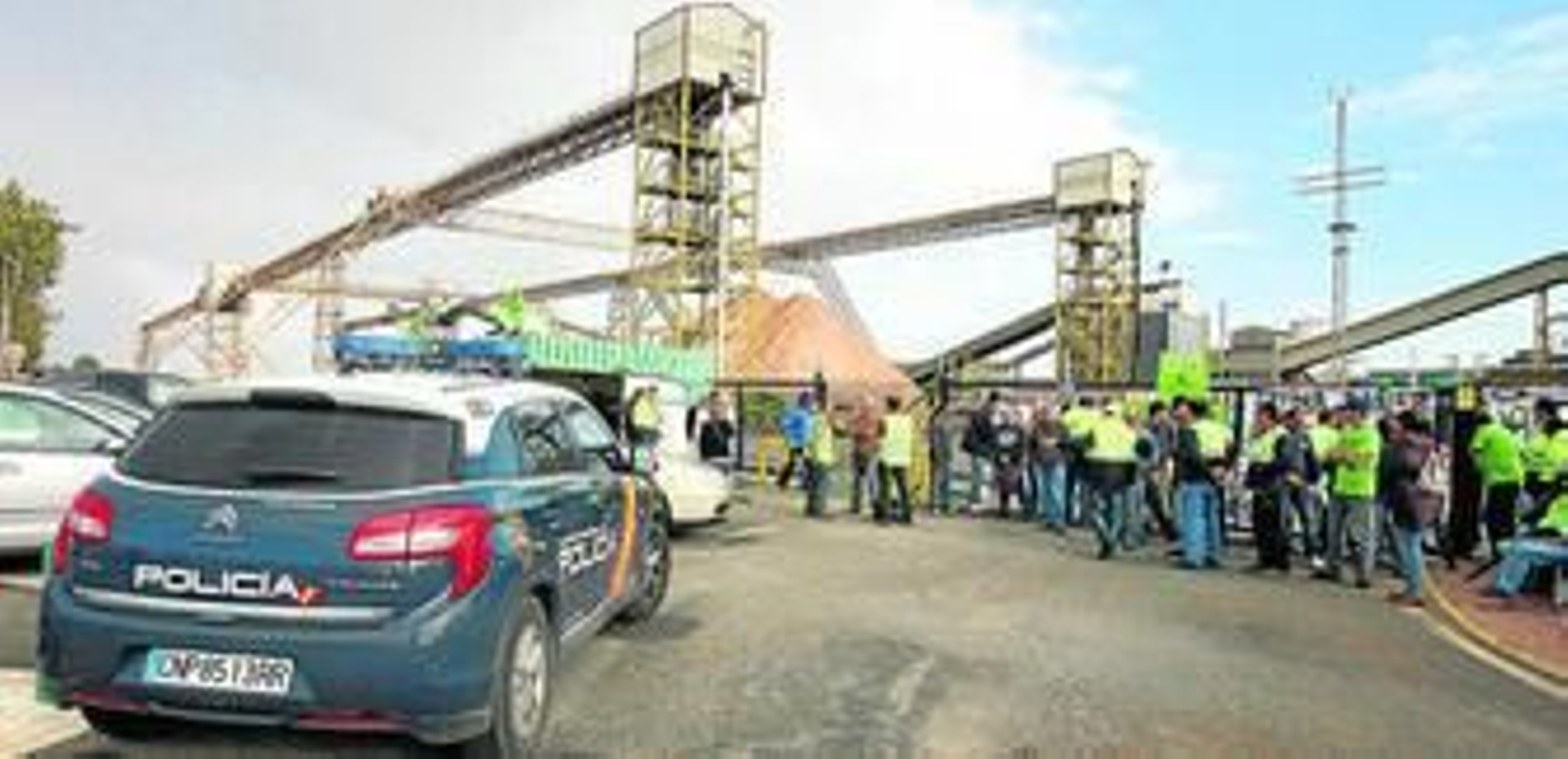 Un coche de la Policía Nacional próximo a los trabajadores de ENCE en huelga, ayer.