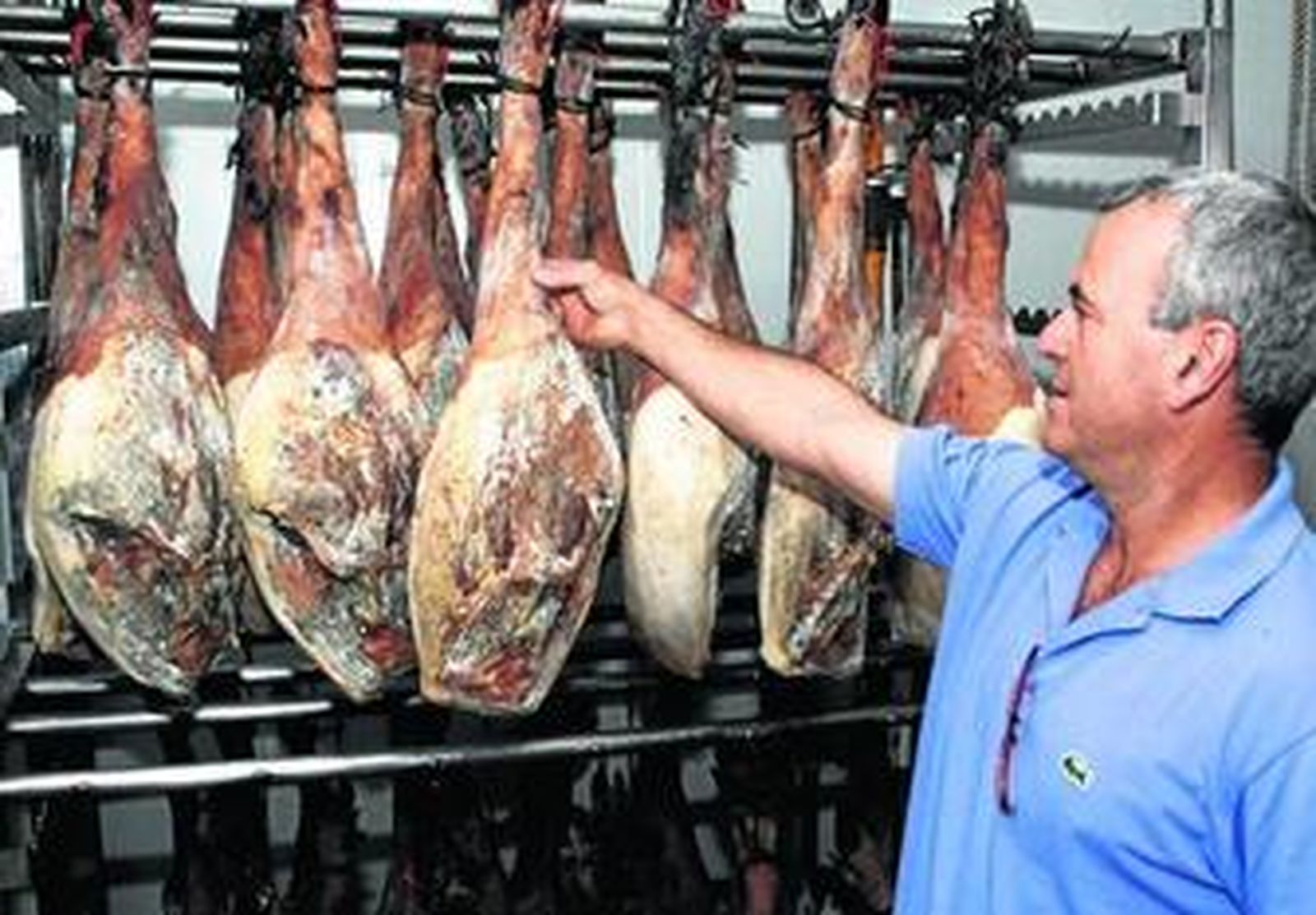 Juan Piñero muestra sus jamones en las instalaciones de la firma en Benaocaz.
